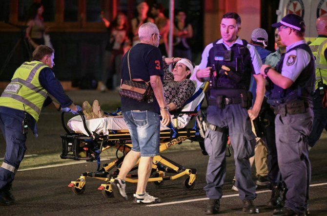 Los trabajadores de la salud trasladan a una mujer en una camilla a una ambulancia después de un tiroteo en Bondi Beach en Sydney el 14 de diciembre de 2025.