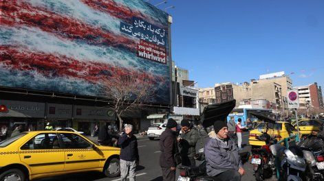 Iraníes caminan cerca de una enorme valla publicitaria antiestadounidense en la plaza Enqelab de Teherán, Irán, el 31 de enero de 2026.