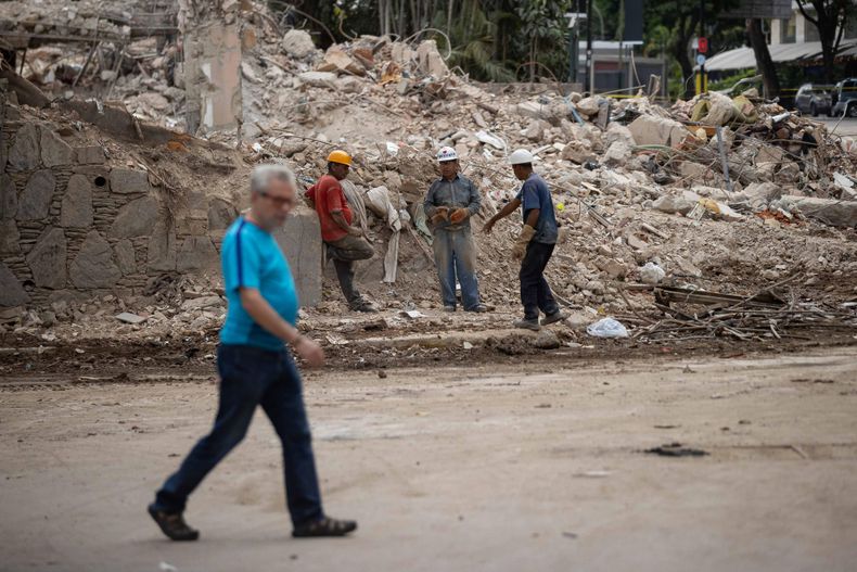 Personas retiran este jueves escombros de un edificio afectado por el doble terremoto en Caracas (Venezuela).