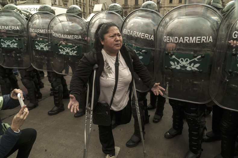 Una persona se manifiesta frente a integrantes de Fuerzas Armadas, durante una protesta contra el veto a la ley de emergencia en discapacidad, frente al Congreso en Buenos Aires