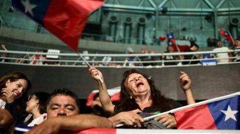 Una mujer ondea una bandera de Chile durante el cierre de campaña del candidato a la Presidencia de Chile José Antonio Kast este martes, en el Movistar Arena, Santiago (Chile).