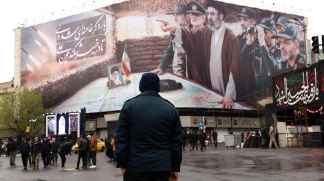 Un miembro de las fuerzas de seguridad iraníes monta guardia frente a una valla publicitaria que muestra al Líder Supremo iraní, Mojtaba Khamenei, y a comandantes militares iraníes durante una manifestación para conmemorar el Día Internacional de Al-Quds en Teherán, Irán, el 13 de marzo de 2026.&nbsp;