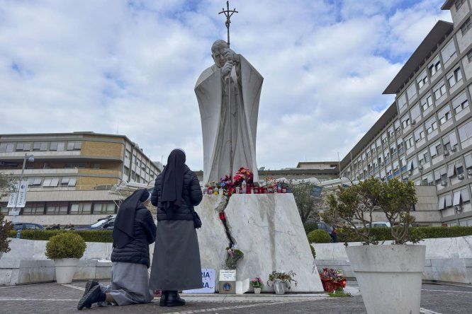Fieles improvisan un altar por el papa con flores y velas a las puertas del hospital Gemelli de Roma, 21 de febrero 2025.