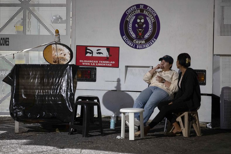 Personas esperan la excarcelación de sus familiares este sábado, frente al comando de la Policía Nacional Bolivariana (PNB) conocido como Zona 7, en Caracas (Venezuela).