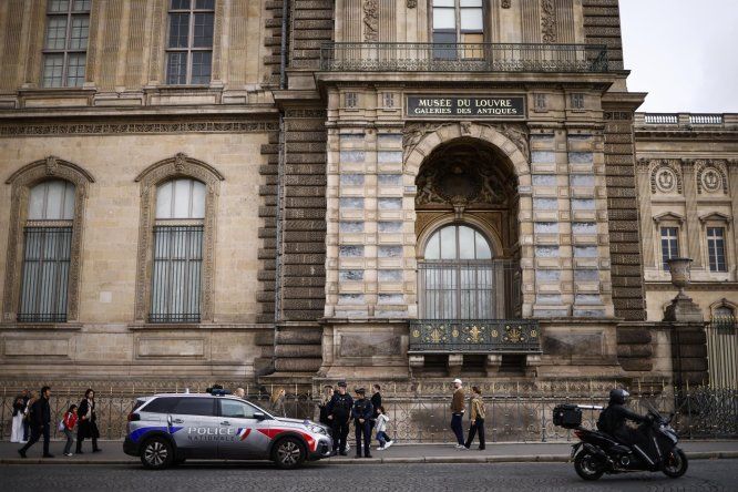 Agentes de la policía francesa se encuentran junto a una ventana rota un día después del robo en el Museo del Louvre de París, Francia, el 20 de octubre de 2025.&nbsp;