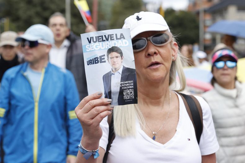 Una mujer sostiene un cartel durante una caminata por la paz y en apoyo al senador Miguel Uribe Turbay este domingo, en Bogotá (Colombia).&nbsp;