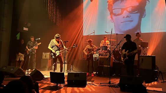 Juan Aguirre Zavala, Xavier Pereira, el Gavilán, Trevor Podargo, Calvin Rodríguez y Nicolás Millot en escena, con la imagen de Renzo Teflón