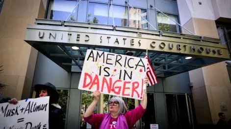 Manifestantes se congregan frente al juzgado Ronald V. Dellums durante un juicio entre Elon Musk y OpenAI en Oakland, California.