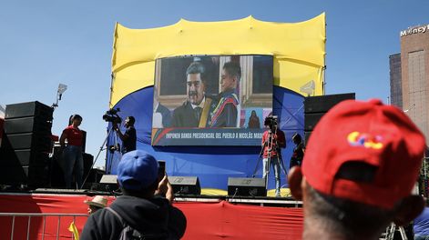 Un partidario del presidente de Venezuela, Nicolás Maduro, toma una foto de una pantalla gigante que transmite la toma de posesión presidencial, en Caracas, el 10 de enero de 2025.