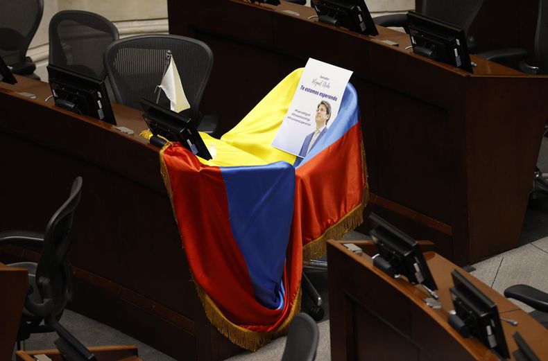 Fotografía de la curúl del senador Miguel Uribe Turbay cubierta con la bandera de Colombia este lunes, en Bogotá (Colombia). La familia del senador y precandidato presidencial de Colombia atacado el fin de semana, Miguel Uribe Turbay, presentó una denuncia penal contra la Unidad Nacional de Protección (UNP), adscrita al Ministerio del Interior, por presunta negligencia respecto a las peticiones para reforzar su seguridad