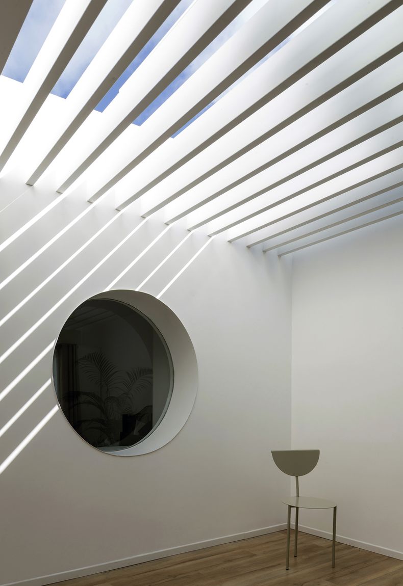 La abertura circular en una de las paredes es un recurso característico utilizado por el estudio. Permite tener una visión desde el frente hasta el patio posterior. La silla O también fue diseñada por Mass arquitectos. Fotos: Marcos Guiponi
