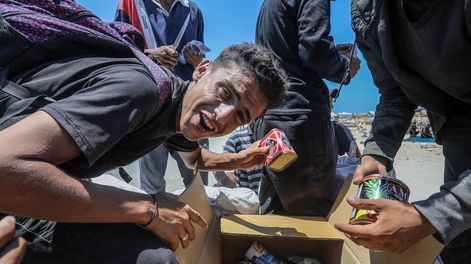 Un ciudadano de Gaza celebra al recibir un paquete de comida, ante la crisis alimentaria que vive el territorio palestino y que numerosos gobiernos internacionales achacan a Israel 