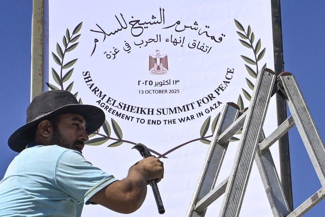 Un trabajador municipal coloca un cartel en Sharm el-Seij, mientras la ciudad turística egipcia se prepara para albergar una cumbre de paz en Gaza, mediada por Estados Unidos, el 12 de octubre de 2025.