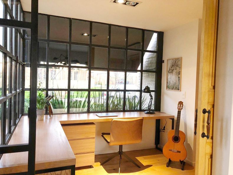 El home office fue uno de los espacios recientemente creados en la casa. Integrado al living y con vistas hacia la fachada del hogar se diseñó un espacio funcional con un amplio escritorio de roble y una silla de cuero