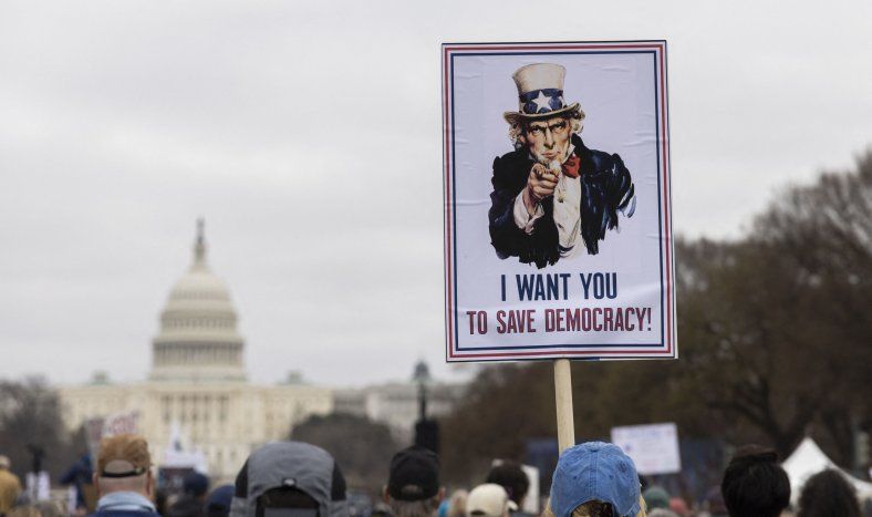 Un manifestante sostiene un cartel con el texto “Quiero que salven la democracia” durante la “Marcha de los Veteranos” en el National Mall de Washington, D.C., el 14 de marzo de 2025.