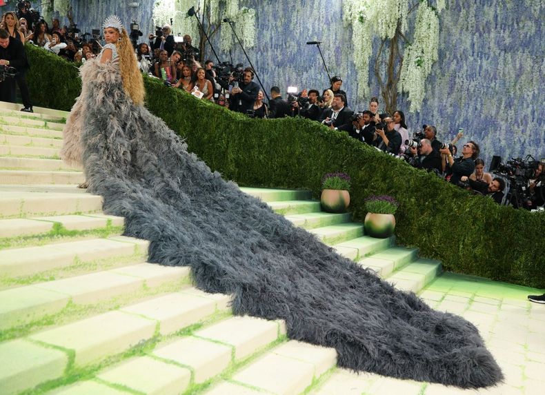 El look más impactante de la noche se hizo esperar: Beyoncé llegó a la gala como anfitriona con un vestido de Balmain acompañado de un abrigo de plumas con una kilométrica cola que requirió la ayuda de cinco personas para subir las escaleras.  