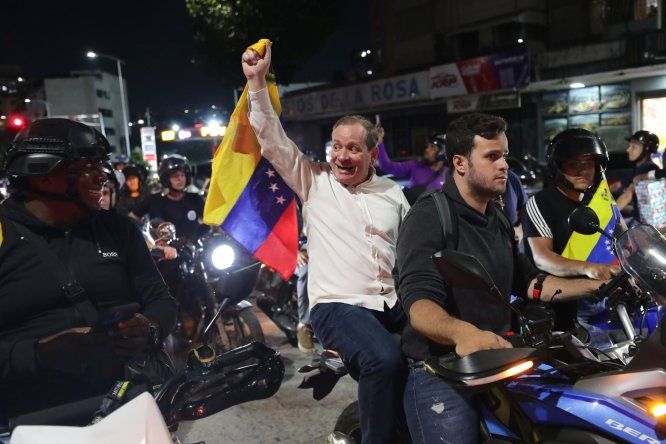 El opositor Juan Pablo Guanipa (c) sostiene una bandera de Venezuela en una manifestación este domingo, en Caracas (Venezuela).