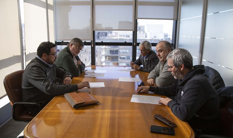 Las autoridades del Poder Ejecutivo y los representantes de COFE, firmando la suspensión del régimen de certificaciones