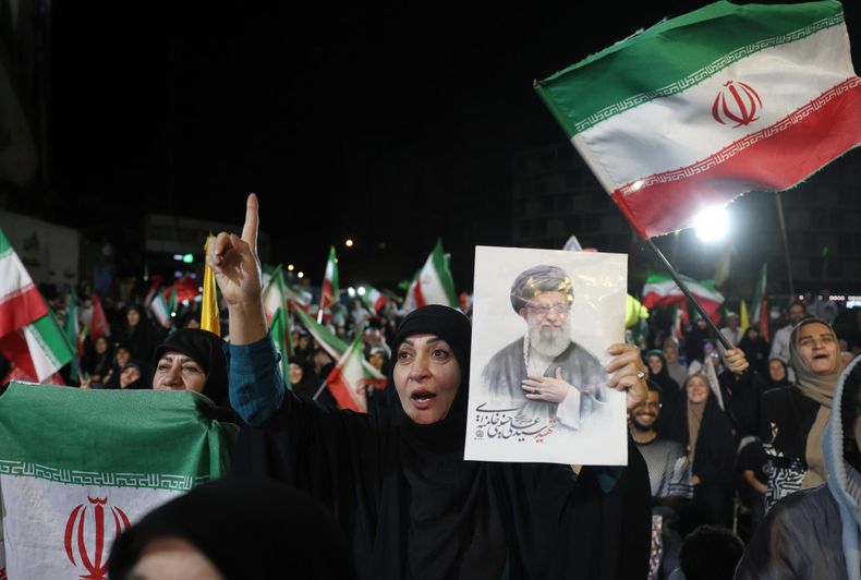 Una mujer sostiene una fotografía del difunto Líder Supremo, el ayatolá Ali Khamenei, mientras la gente se reúne durante una manifestación tras el ataque iraní contra Israel, en la plaza Valiasr de Teherán, Irán, el 7 de junio de 2026.