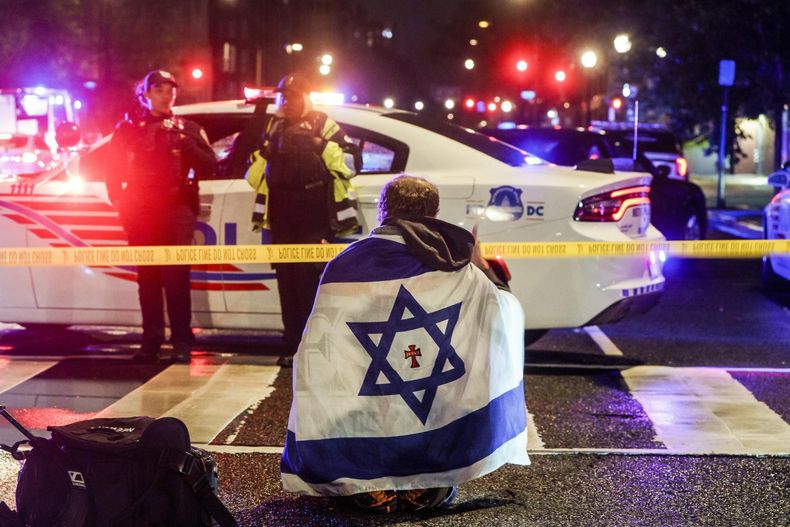 Un hombre con una bandera israelí sobre los hombros cerca del lugar donde dos personas fueron asesinadas a tiros cerca del Museo Judío Capital en Washington, D.C., EE. UU., el 22 de mayo de 2025