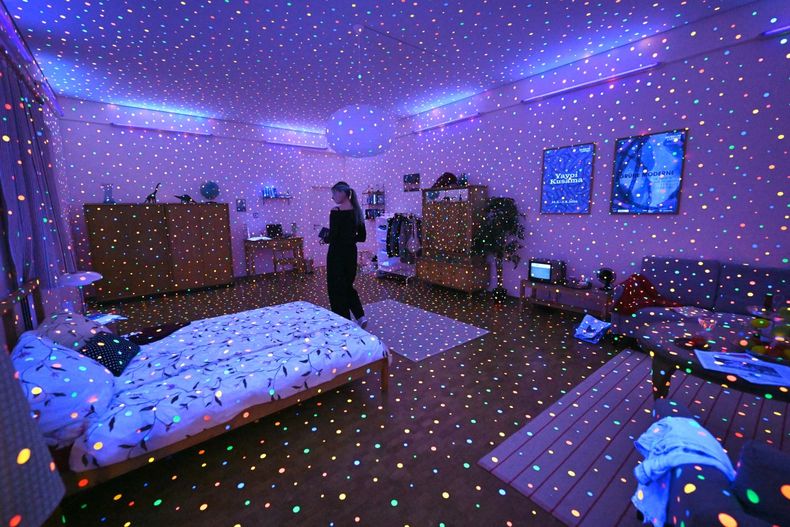 I'm here, but nothing es una serie que muestra ambientes domésticos iluminados con luz negra y cubiertos por puntos fluorescentes pegados por toda la superficie.  