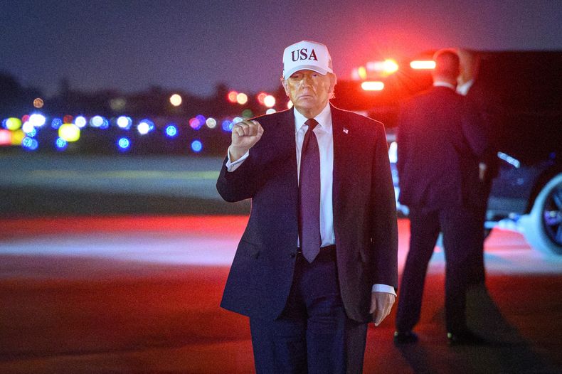 Donald Trump hace un gesto al llegar al Aeropuerto Internacional de Palm Beach en Florida, previo a iniciar el ataque a Irán.