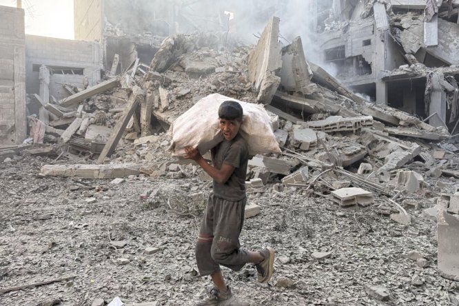 Una persona camina por los escombros tras uno de los ataques lanzados este domingo por Israel en Gaza.