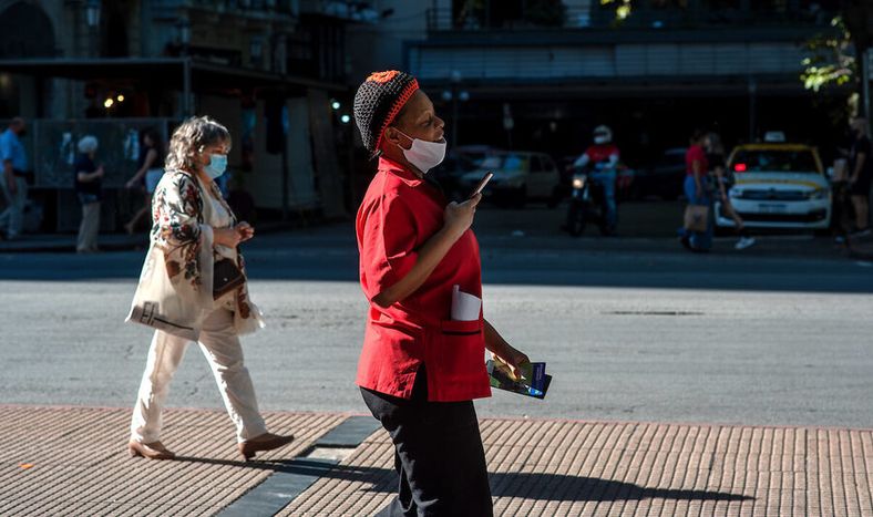 Mujer con celular en la Avenida 18 de julio. Foto: Ricardo Antúnez / adhocFOTOS