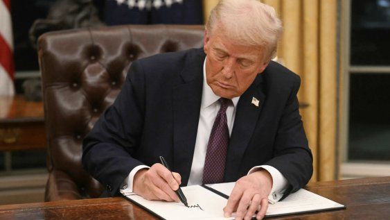 Donald Trump firma una orden ejecutiva en la Oficina Oval de la Casa Blanca.