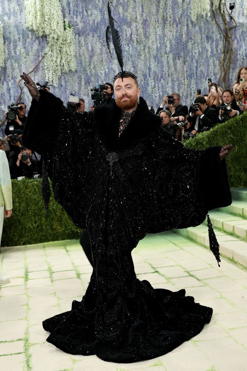 Fiel a su estilo teatral y dramático, Sam Smith llegó a la alfombra roja con un impactante diseño de Christian Cowan, acompañado por un tocado de plumas. 
