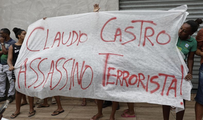 Personas sostienen un cartel contra el gobernador de Río de Janeiro, Claudio Castro, este miércoles en Río de Janeiro (Brasil).