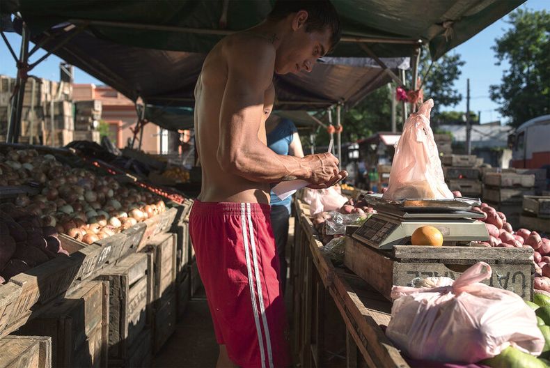 Un joven trabajando en una feria de frutas y verduras en barrio La Figurita. Foto: Ricardo Antúnez / adhocFOTOS