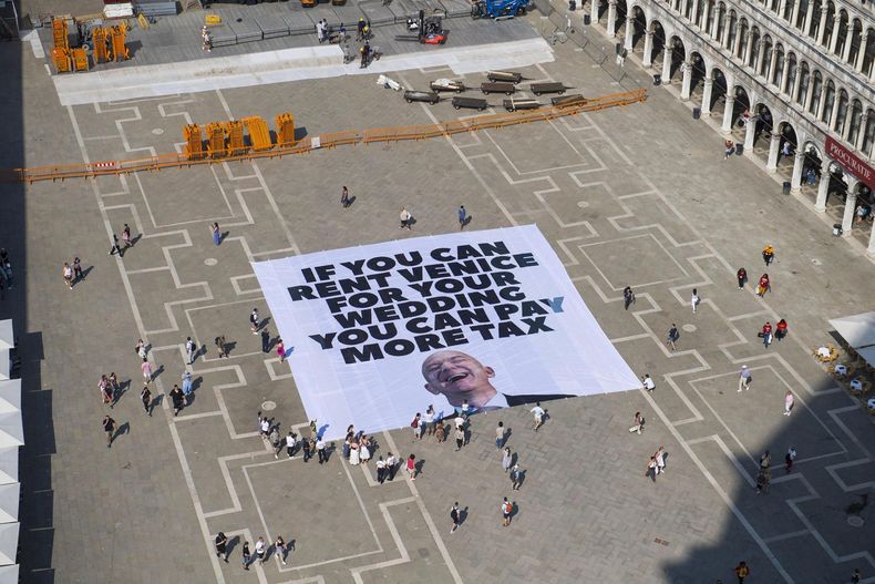 Una fotografía facilitada por la oficina de prensa de Greenpeace muestra a activistas del grupo ambiental Greenpeace desplegando una pancarta gigante con la imagen del empresario estadounidense y fundador de Amazon, Jeff Bezos, y un eslogan que dice Si puedes alquilar Venecia para tu boda, puedes pagar más impuestos en la Plaza de San Marcos en Venecia, Italia, el 23 de junio de 2025