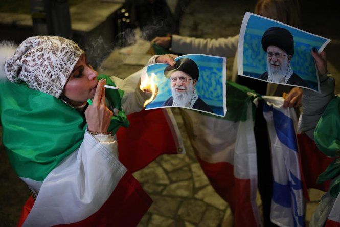 Una integrante de la comunidad iraní israelí quema una foto del líder supremo de Irán, Ali Khamenei, durante una protesta en apoyo al pueblo iraní, en Holon (Israel).