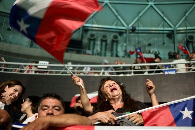 Una mujer ondea una bandera de Chile durante el cierre de campaña del candidato a la Presidencia de Chile José Antonio Kast este martes, en el Movistar Arena, Santiago (Chile).