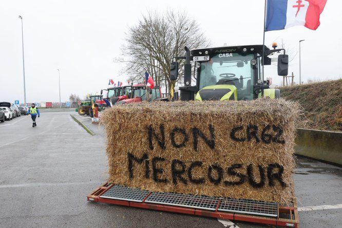 Una paca de heno con la inscripción “No al Mercosur” se coloca en un tractor mientras agricultores participan en un bloqueo en la autopista A1 cerca de Fresnes-lès-Montauban, Paso de Calais, el 12 de enero de 2026.