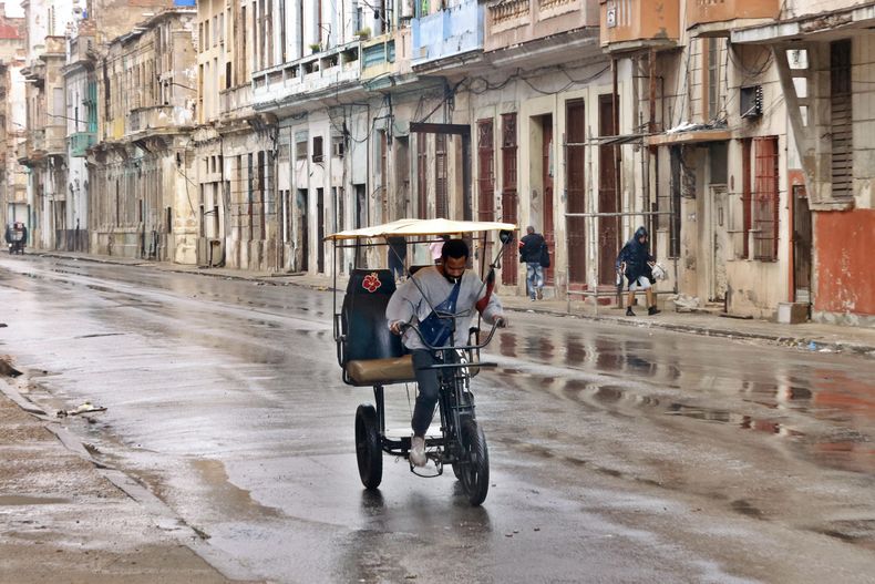 Un hombre conduce un bicitaxi por una calle este domingo, en La Habana (Cuba)