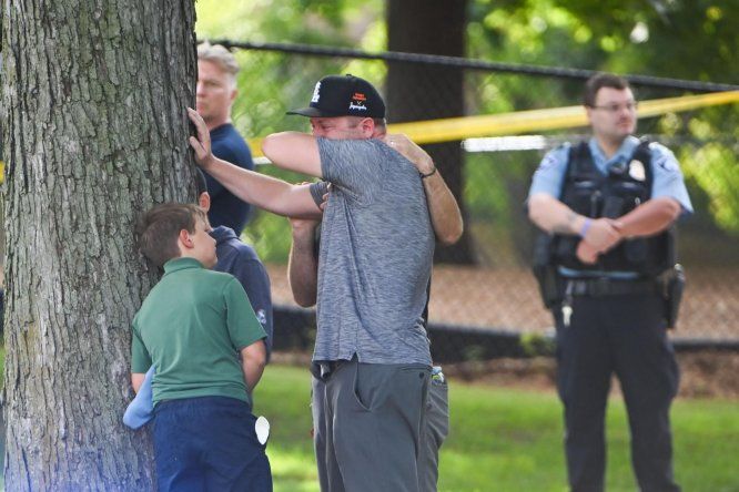 Un adulto y un niño salen de la escuela mientras la policía responde a un tiroteo en la Escuela Católica Annunciation en Minneapolis, Minnesota, EE.UU., el 27 de agosto de 2025.