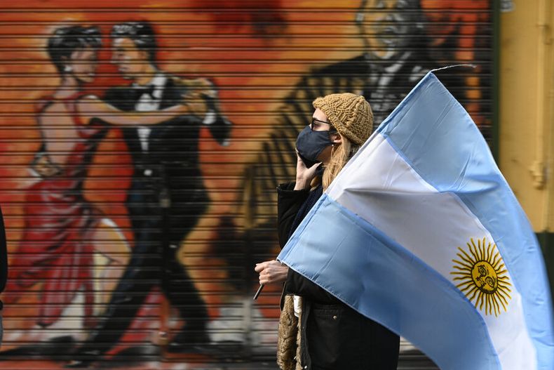 Una mujer sostiene una bandera argentina durante una protesta contra las políticas del presidente de Argentina, Alberto Fernández. Foto: AFP.