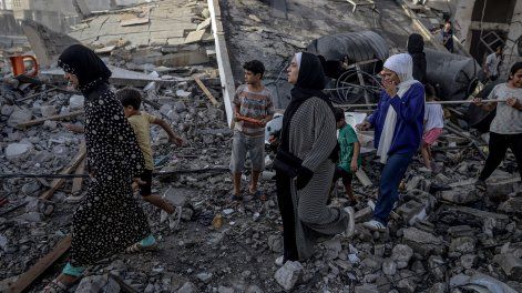 Personas, caminando sobre escombros, abandonan la zona tras el ataque israelí en la calle Omar al-Mukhtar de la ciudad de Gaza, el 3 de octubre de 2025.