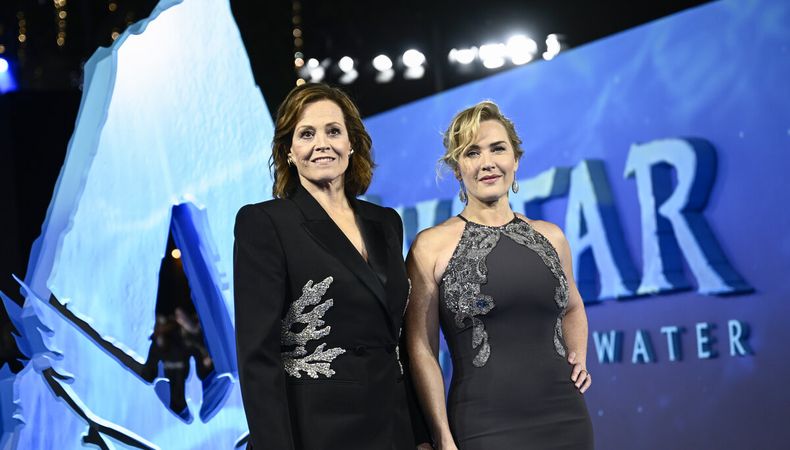 Las actrices Sigourney Weaver y Kate Winslet posan en una alfombra roja que se tiñó de azul para la avant première de Avatar: el camino del agua. AFP.