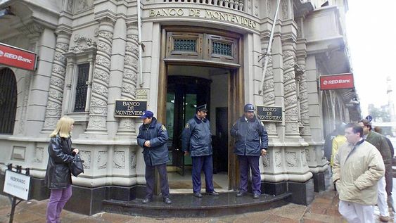 Policías vigilan la casa central del Banco Montevideo durante la crisis de 2002. Foto: AFP