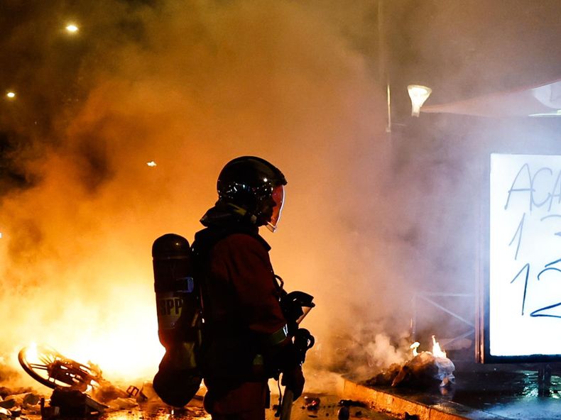 Un bombero francés acude a sofocar el incendio de una barricada en París, Francia, el 18 de octubre de 2026, en el marco de los enfrentamientos entre la policía antidisturbios y los manifestantes.