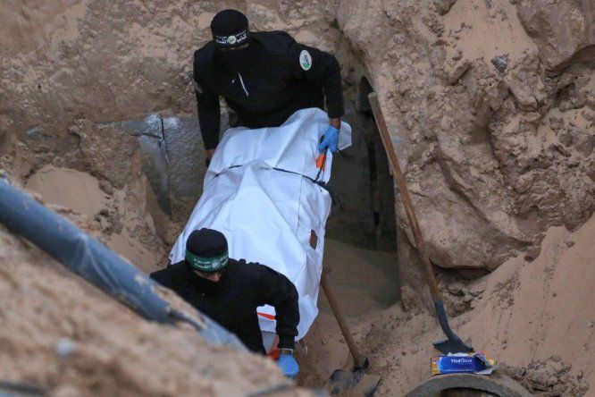Militantes de Hamás cargan un cuerpo recuperado de un túnel en una zona al norte de Jan Yunis, en el sur de la Franja de Gaza, el 28 de octubre de 2025.