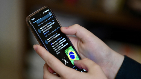 Un usuario brasileño de la red social X, antes Twitter, consulta publicaciones en un teléfono celular en Brasilia