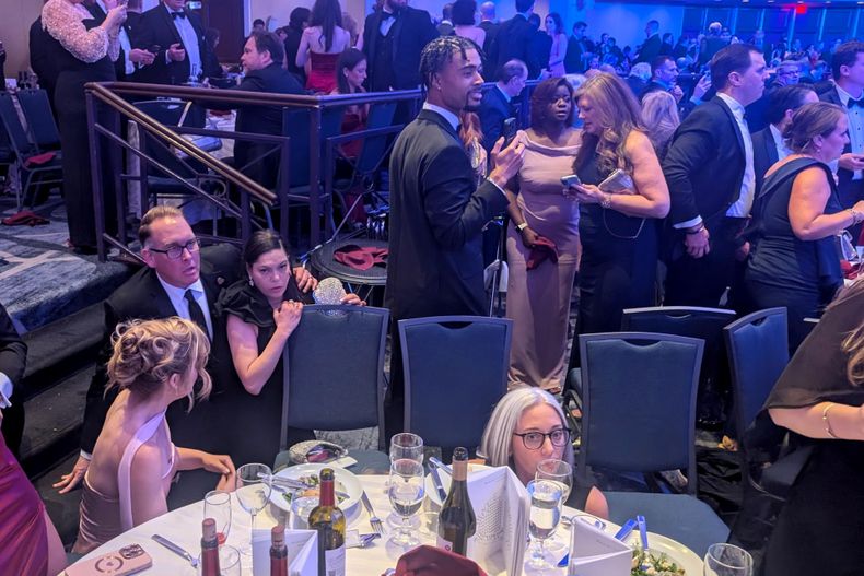 Personas reaccionan tras escuchar aparentes disparos durante la cena anual de la Asociación de Corresponsales de la Casa Blanca (WHCA) este sábado, en Washigton (Estados Unidos).