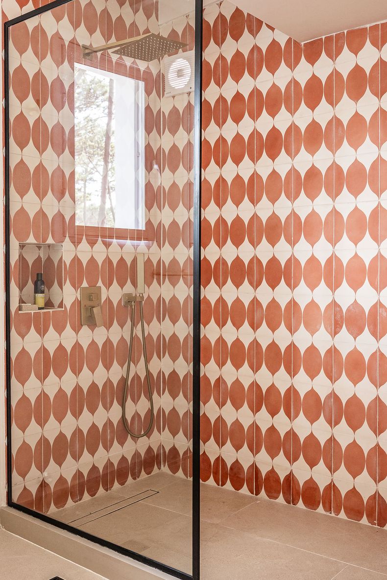 Los baños fueron renovados completamente y se escogieron materiales como mármol y grifería en tono bronce mate, manteniendo las líneas curvas y la coherencia estética de la casa.