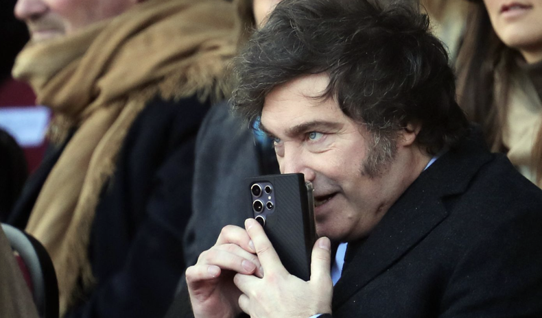 Javier Milei utiliza su celular en un acto oficial.