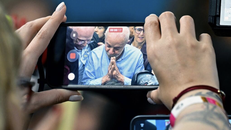 El presidente de Brasil y candidato a la reelección, Luiz Inácio Lula da Silva, aparece en las pantallas de teléfonos móviles y cámaras mientras habla durante un encuentro con legisladores actuales y recién elegidos en un hotel de Brasilia, el 7 de octubre de 2026.