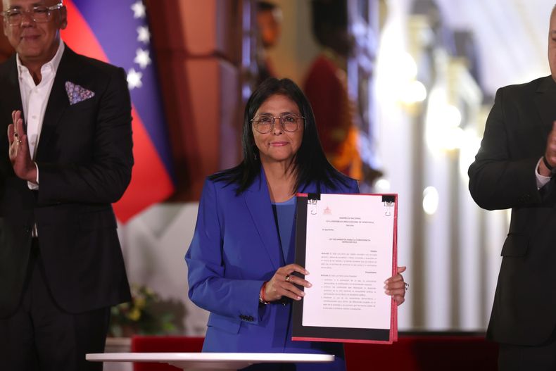 La presidenta encargada de Venezuela, Delcy Rodríguez, sostiene el documento de la ley de amnistía, en Caracas.